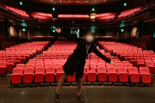 Standing in the center of the stage and taking a commemorative photo
