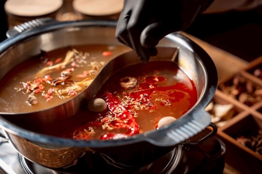 仕切りのついた鴛鴦鍋で２種類の味付けを同時に堪能できます